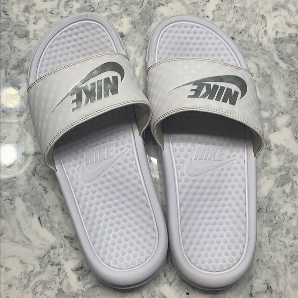 White and silver Nike slides